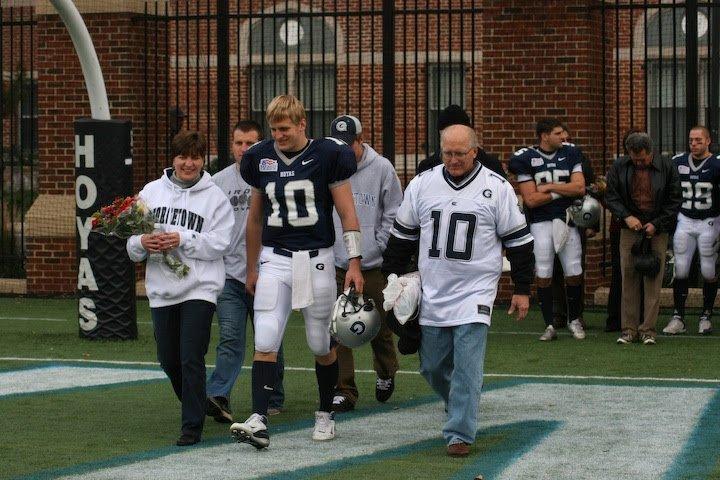 Matthew Bassuener in a Georgetown Hoyas number 10 uniform, walking the field with his parents